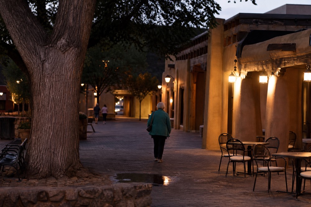 Charming small-town plaza with historic buildings and leafy trees, no text, no logos, no people