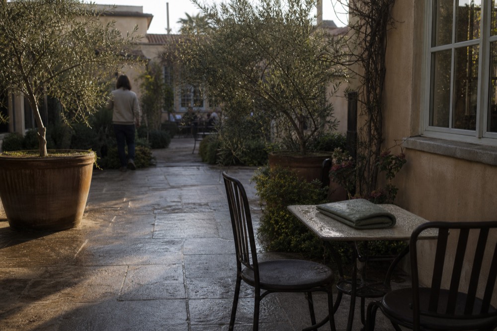 A modest wine country inn courtyard with morning light, no text, no logos, no people.