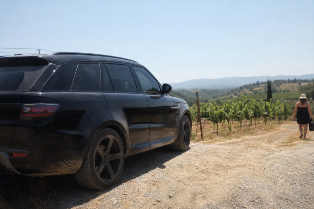 Private luxury SUV parked in front of a Sonoma vineyard, no text, no logos, no people