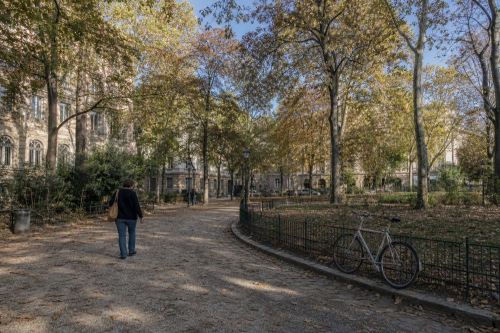 Pedestrian path around the Sonoma Plaza green with historic facades, no text, no logos, no people