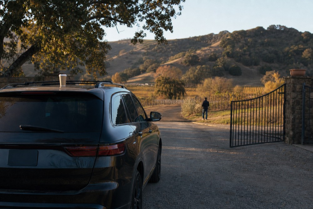 A luxury SUV parked in front of a Sonoma winery entrance, no text, no logos, no people