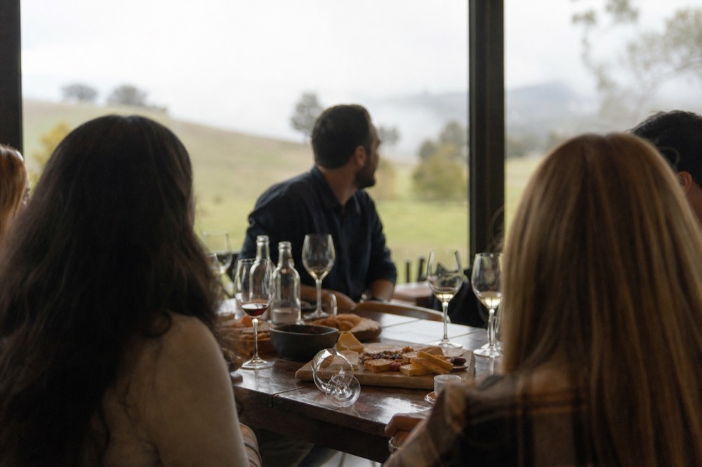 A group of friends laughing around a tasting table, no text, no logos, no people
