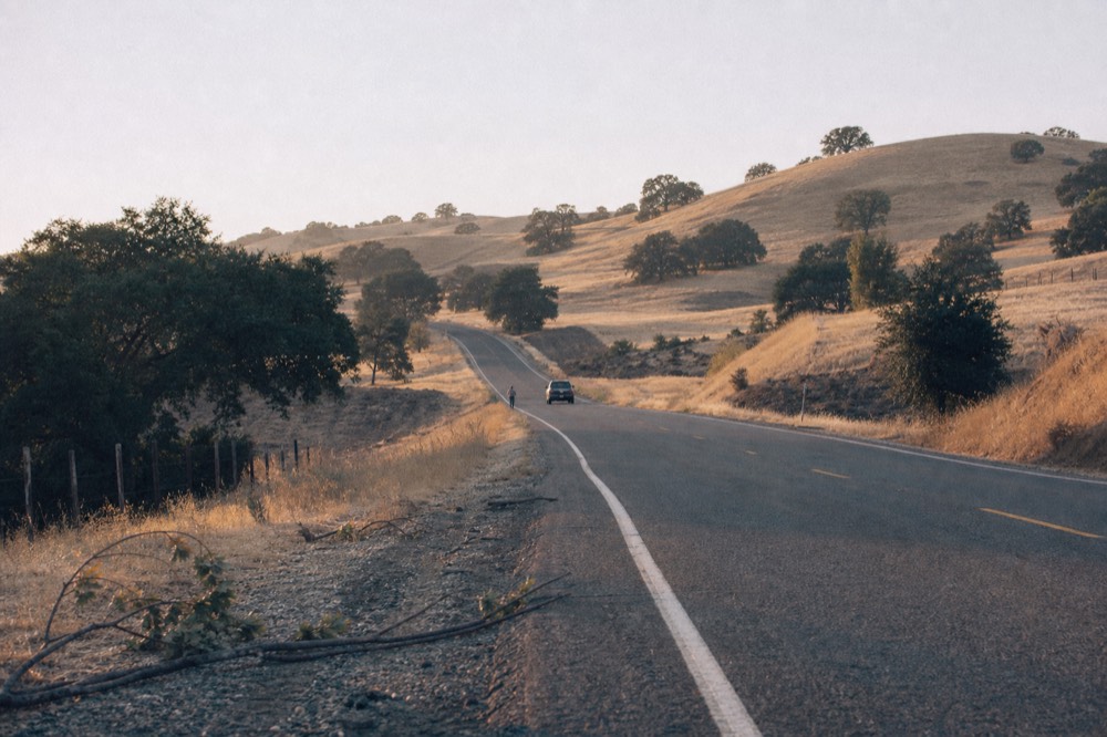 Highway cutting through rolling hills between Santa Rosa and Healdsburg wine country, no text, no logos, no people