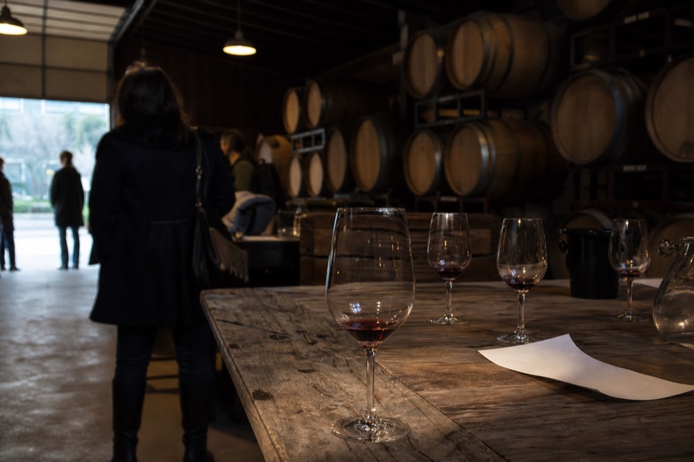 Tasting room interior with barrel storage and wine glasses, no text, no logos, no people